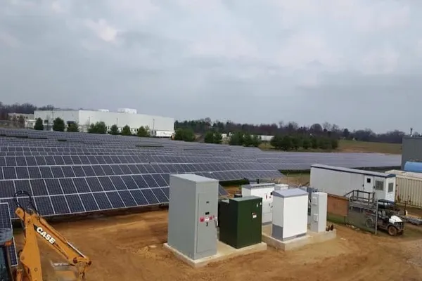 Ground-mounted solar array with electrical switchgear at an industrial site